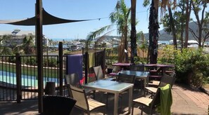 Outdoor pool, pool loungers - Backpackers By The Bay (Airlie Beach)