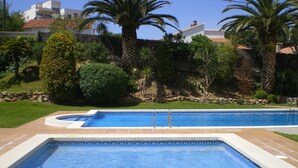 A rectangular swimming pool with a tiled edge, surrounded by a stone wall and lush greenery including palm trees and shrubs. - IMPRESSIVE VIEWS, POOL-GARDEN, CLIMATIZACION, WiFi. NEAR SEA HUTG-02835 (L´escala)