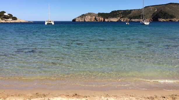 A beach with clear water, a sandy shore, and two sailboats anchored near rocky cliffs. - IMPRESSIVE VIEWS, POOL-GARDEN, CLIMATIZACION, WiFi. NEAR SEA HUTG-02835 (L´escala)