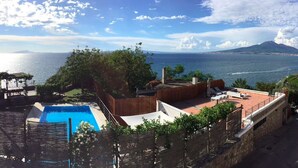 A rooftop pool area with a view of the sea and a mountain. - Villa Bikini, a paradise on the rock steep above the sea with swimming pool. (Napoli)