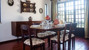 A dining room with a wooden table set for four, surrounded by upholstered chairs. A wooden buffet shelf with decorative plates is above the table. - Detached villa with private pool 1.5 km from Vilamoura marina (Vilamoura, Loule)