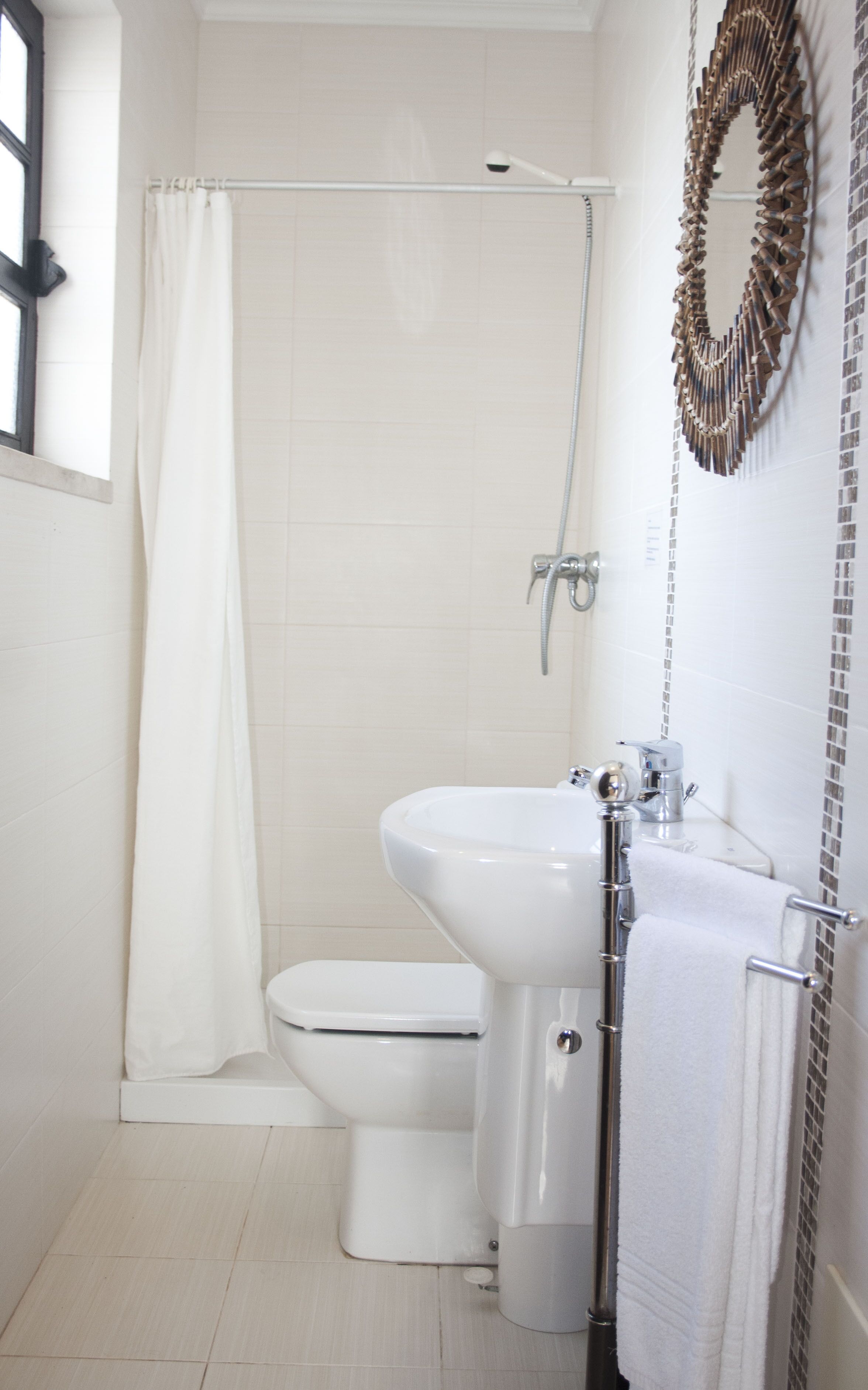 A bathroom with a shower, toilet, and sink.