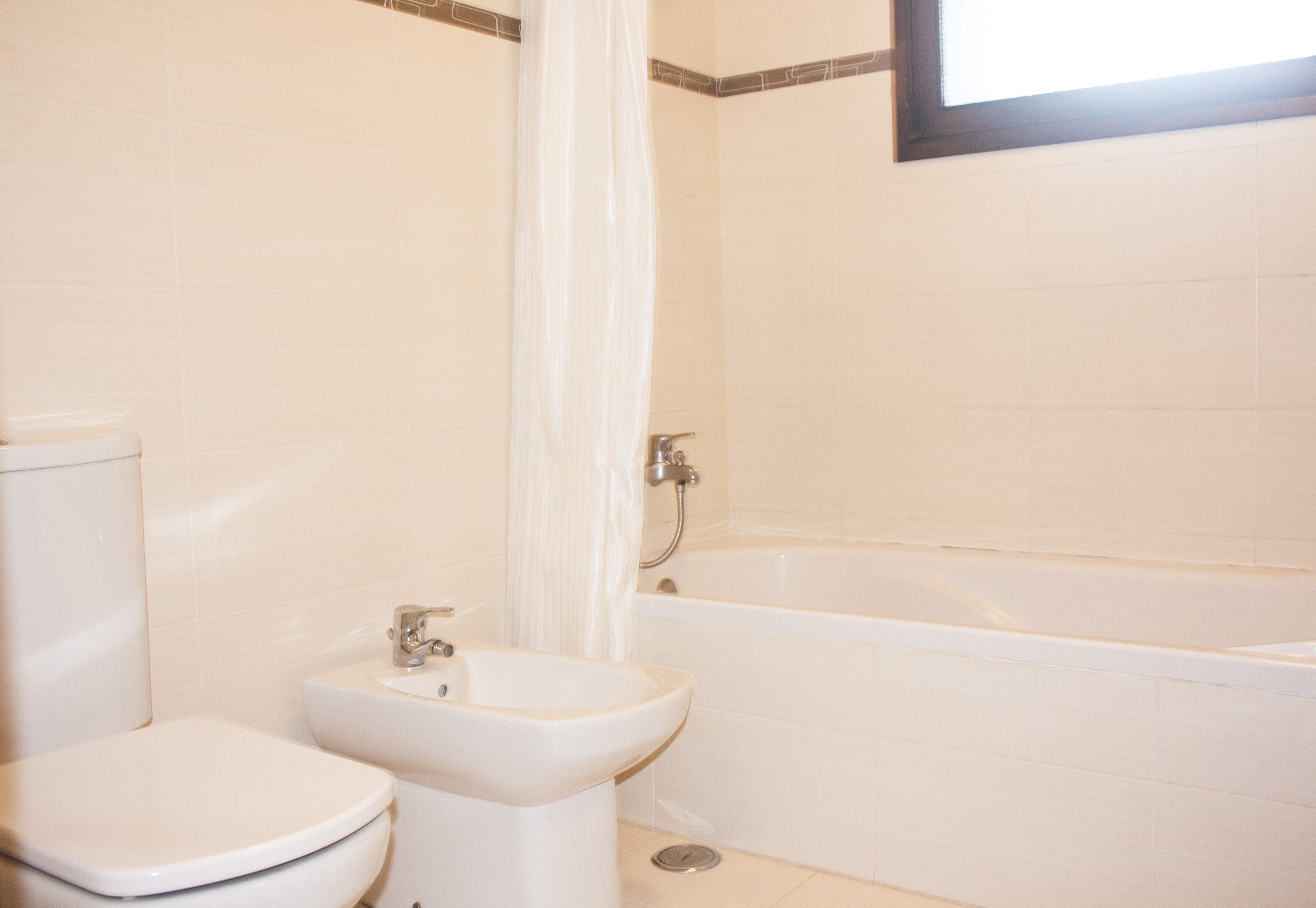 Une salle de bain équipée de toilettes, d’un bidet et d’une baignoire.