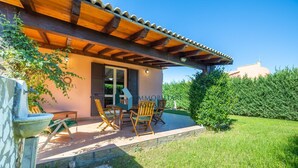 A house with a covered patio, outdoor seating, and a well-maintained garden. - Villa Limuti with shared swimming pool (Cefalù)