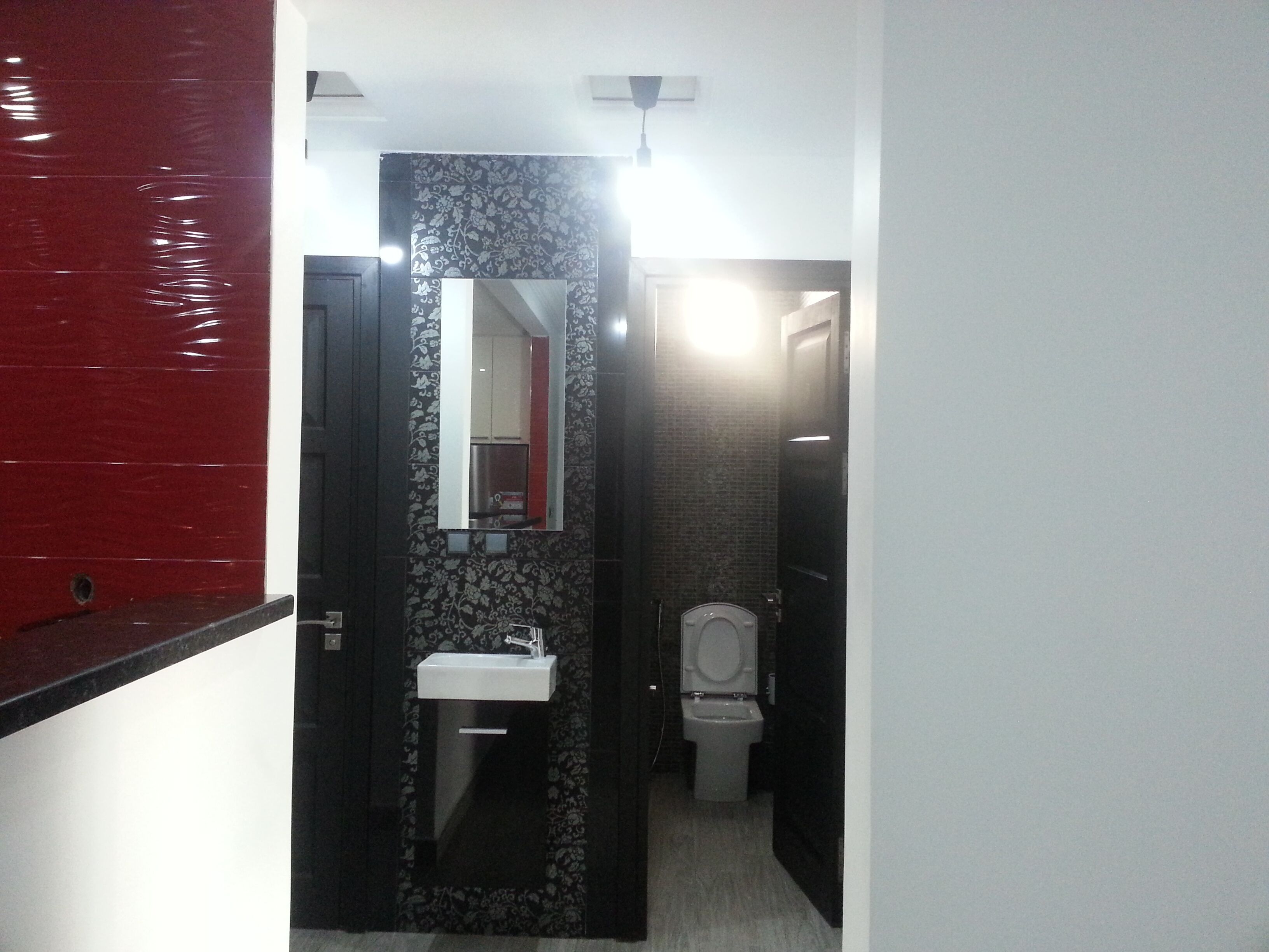 A compact bathroom with a sink, mirror, and toilet.