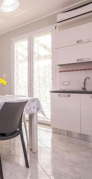 A modern kitchen with a built-in stove, a sink, and a window with a view.