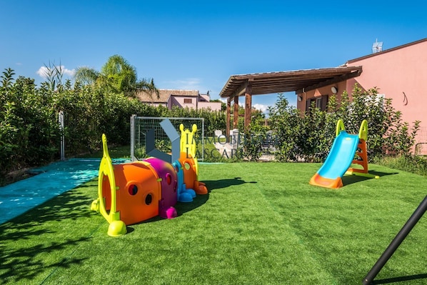 A children's play area with a slide and climbing structures.