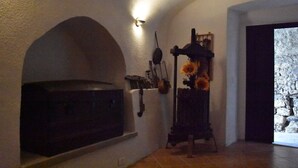 Eine Küche mit Backofen, einer an der Wand befestigten Küchenutensilienhalterung und einer Blumenvase.