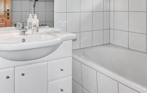 Bathroom features a large sink, mirror, and bathtub.