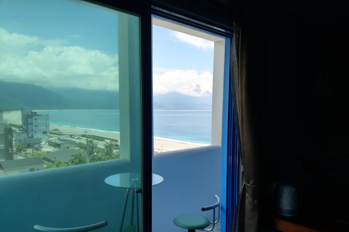 A balcony with a view of the beach and ocean.