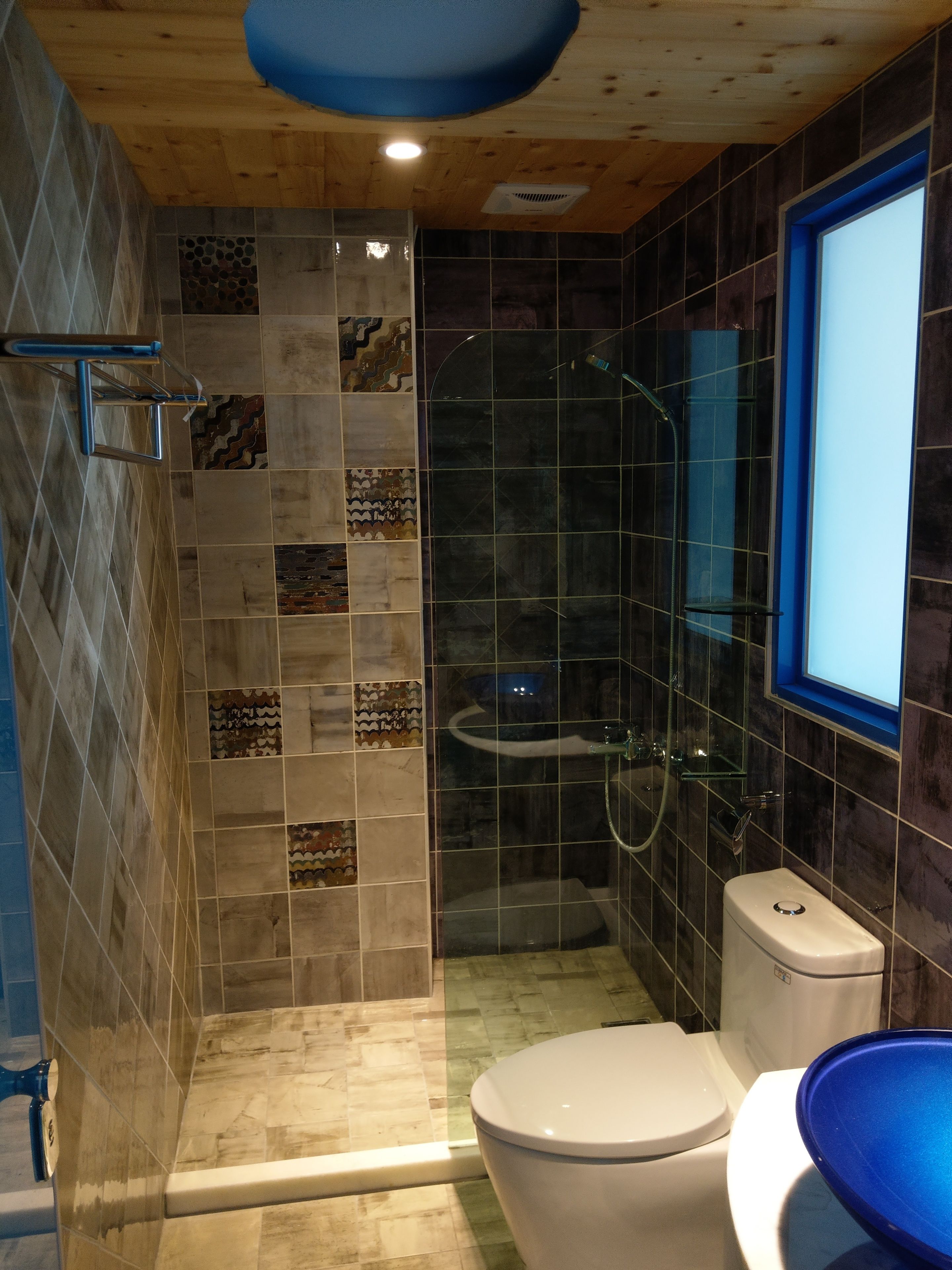 A modern bathroom with a shower, toilet, and sink.