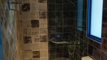 A modern bathroom with a shower, toilet, and sink.