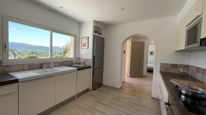 Una cocina moderna con un ventanal grande, suelo de madera y vistas al exterior.