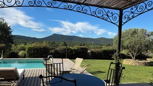 A covered outdoor seating area with a pool, a table, and chairs. - La Maison de Sophie : Luxury Family Villa • Heated Pool • Provence Verte (Garéoult)