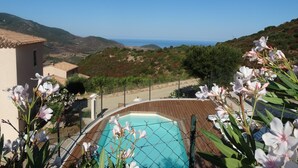 A pool area with a view of the sea and hills. - Gîte-Sassone, gîte with swimming pool, jacuzzi and panoramic sea view. (Ajaccio)