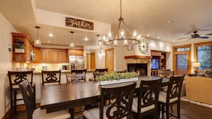 A spacious kitchen with wooden cabinets, a large island, and a chandelier.