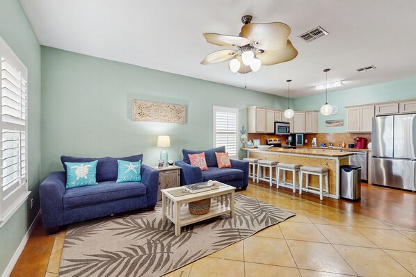 A modern kitchen with a central island, white cabinets, and stainless steel appliances. - Welcoming condo with W/D & pool - near the beach (Corpus Christi)