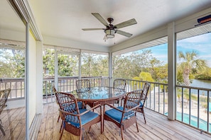 Relax in this serene outdoor space with a glass-top table and wicker chairs, surrounded by breathtaking views of the natural landscape.