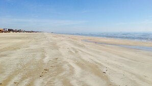 Una extensa playa de arena con cielo despejado.