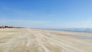 Na praia, espreguiçadeiras, toalhas de praia