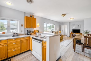 Enjoy meal preparation and dining in this well-equipped kitchen with a central island, stove, and ample counter space.