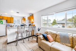 Enjoy a homey atmosphere in this apartment with a kitchen area, comfortable sofa, and a view of the neighborhood.