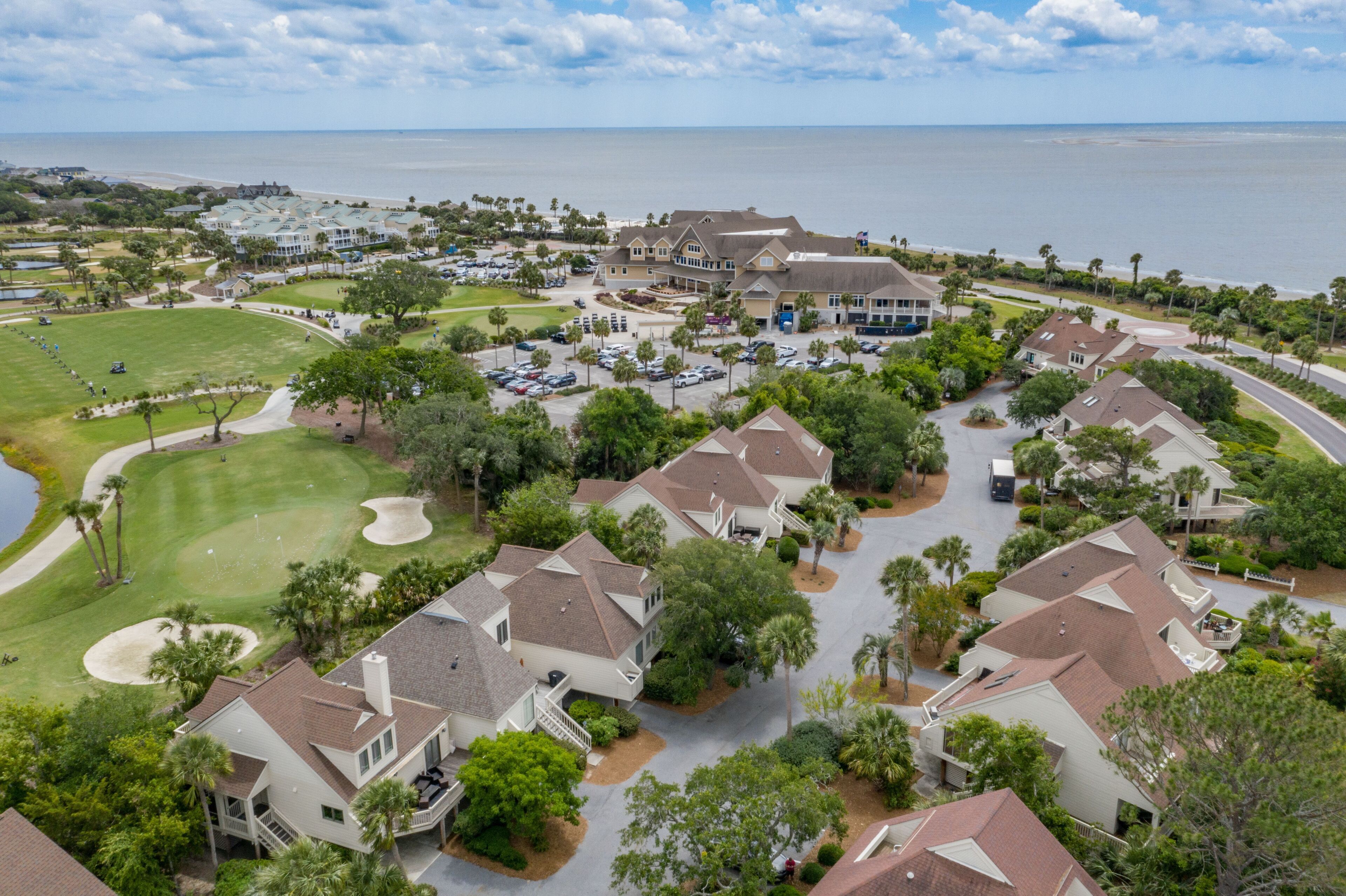 A coastal residential area with houses, a golf course, and a large building with a beach view.