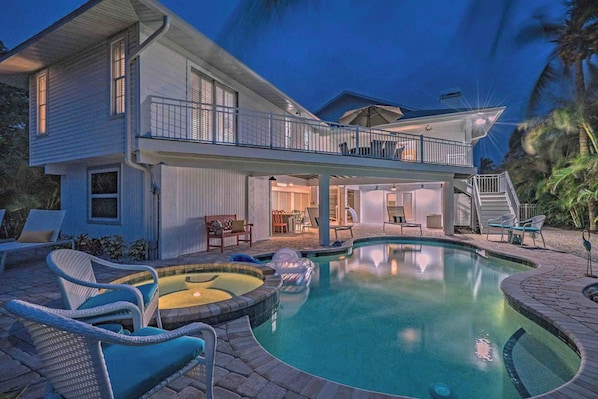 Relax by the pool surrounded by palm trees and lounge chairs on the spacious deck.