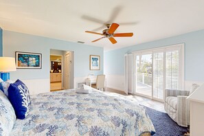 Cozy retreat with a large bed, ceiling fan, and desk area.