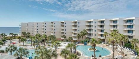 Hotel com vários andares, piscina central e vista para a praia.