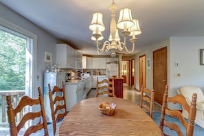 Enjoy meals in this dining area with a large table and six chairs, offering a view of the balcony and the outdoors.