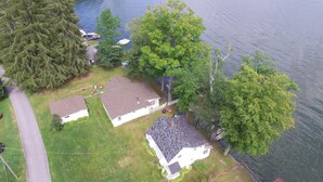 An aerial view of a residential area with houses, a dock, and a lake.