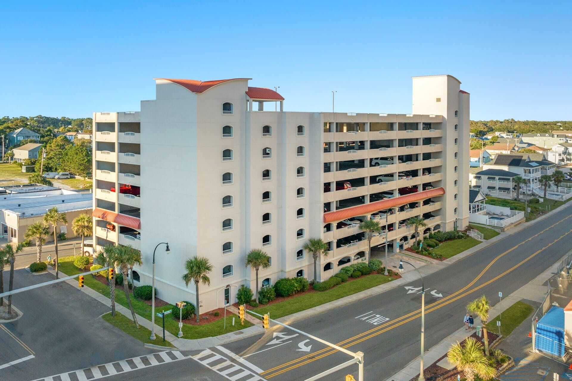 A multi-story hotel with a parking garage, located at a street intersection.