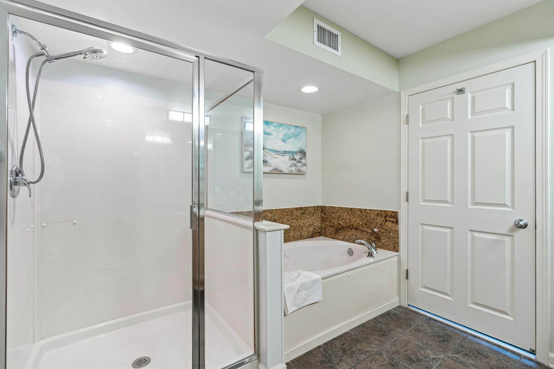 Une salle de bain avec une douche à parois de verre, une baignoire et un lavabo.