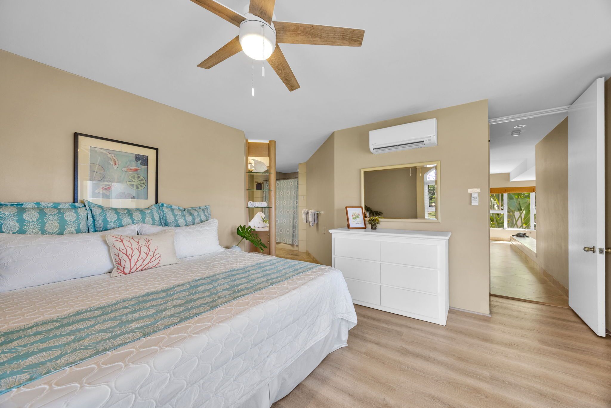 A bedroom with a bed, a ceiling fan, a white dresser, and an air conditioning unit.