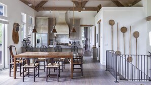 A spacious kitchen with wooden beams, a dining area with a large wooden table and chairs, and a staircase with a railing. - Elegant interior. Sunset views. Walk to town. Professional kitchen. Pet friendly (Highlands)
