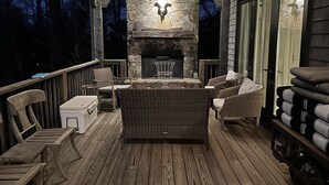 A covered outdoor seating area with stone walls, wicker furniture, and a fireplace. - Elegant interior. Sunset views. Walk to town. Professional kitchen. Pet friendly (Highlands)