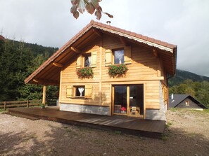 A wooden chalet with a stone foundation, wooden shutters, and a balcony. - Chalet Érable**** - Sauna - 8 Pers | Household, Towels & Beds Made Included (Rochesson)