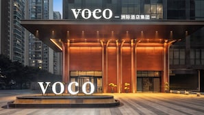 A modern hotel entrance with illuminated signage and a well-lit facade.