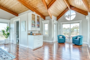 Relax in this serene space with a high ceiling, hardwood floors, and a large window offering a view of the outdoors.