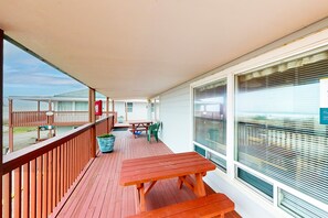 Relax on the covered outdoor space with a wooden table and benches, perfect for dining or unwinding.