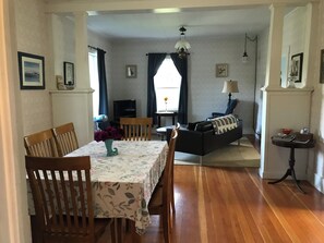 A dining area with a table set for four, a sofa, and a television in the background. - Water front property with spectacular views. (Marrowstone)