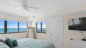 A bedroom with a bed, a television, a dresser, and a door. - 9th Floor Oceanfront Condo, Jacuzzi Tub, Outdoor Pool | Ocean Bay Club - 906 (North Myrtle Beach)