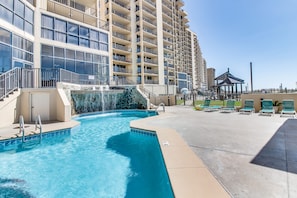 Relax by the pool surrounded by lounge chairs and a gazebo.