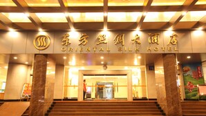 The entrance to the Oriental Silk Hotel with a prominent sign, marble columns, and a set of stairs leading up to the entrance. - Oriental Silk Hotel - Guangzhou (Guangzhou)