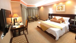 A hotel room with a large bed, a desk with a computer, a chair, and a television. - Oriental Silk Hotel - Guangzhou (Guangzhou)