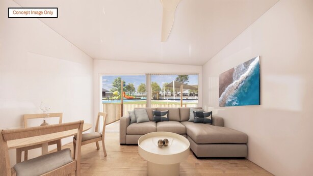 A modern living room with a sofa, a coffee table, and a view of an outdoor pool area. - Discovery Parks - Townsville (Wulguru)
