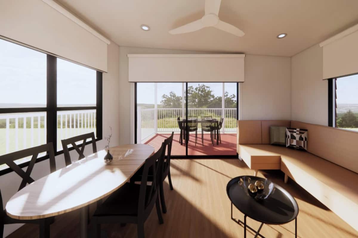 A modern interior with a dining table, chairs, a sofa, and large windows offering views.