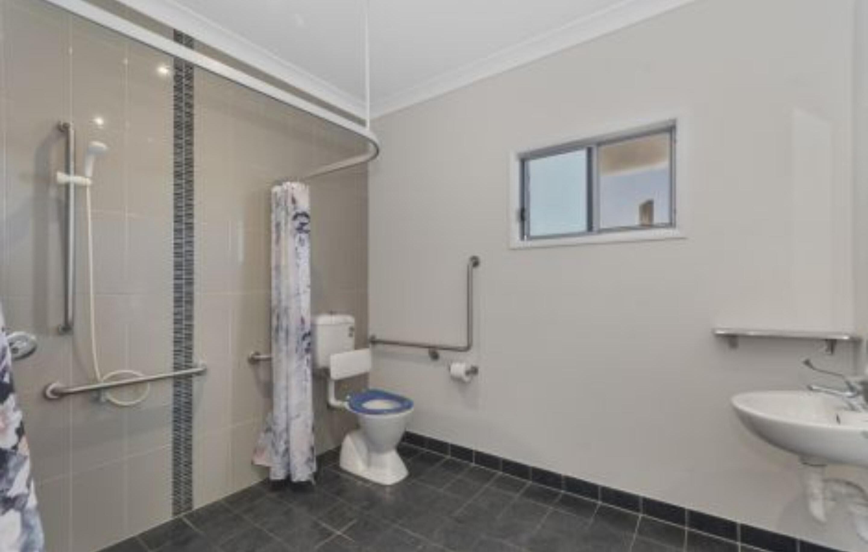 A bathroom with a shower, toilet, and sink.