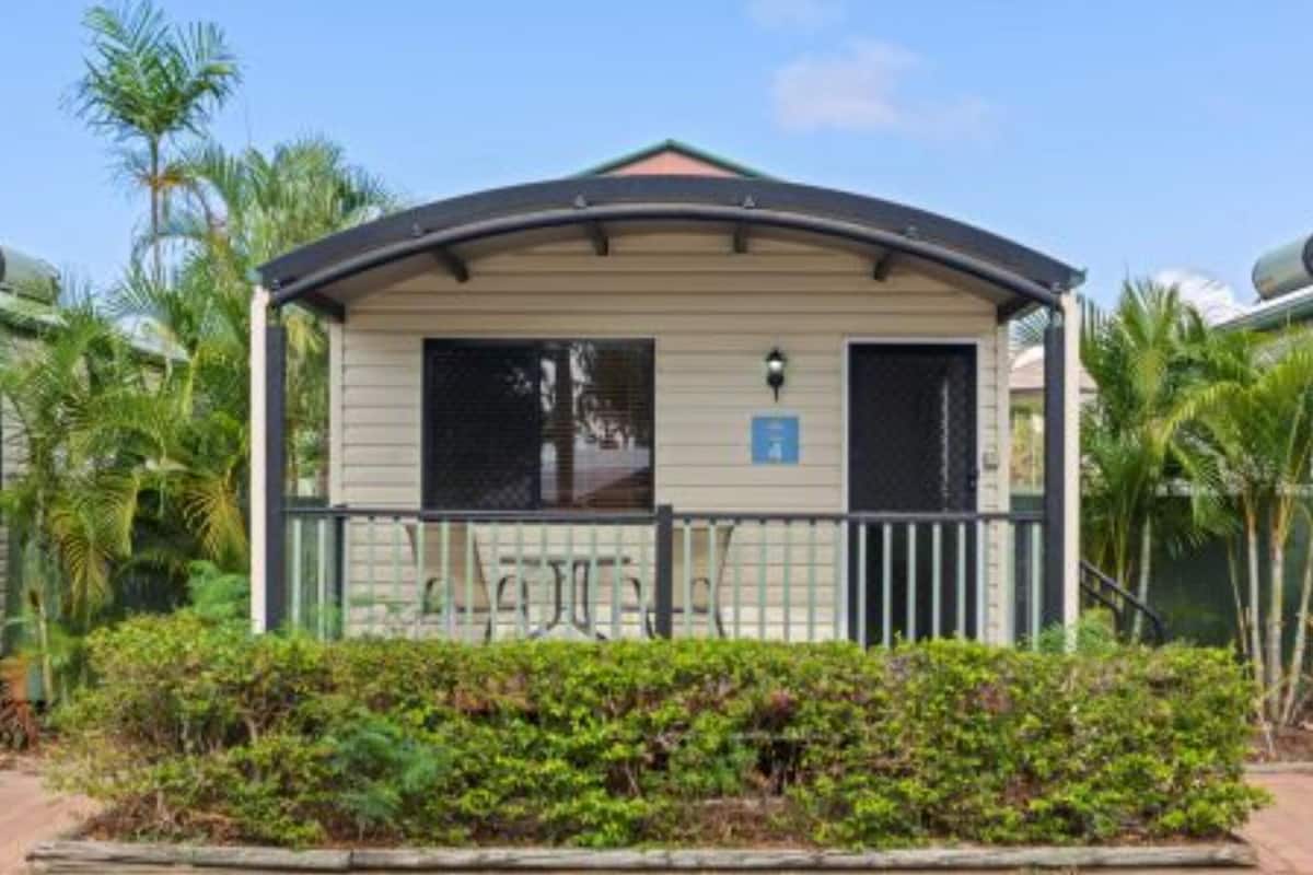 A small, single-story building with a curved roof, a gated entrance, and a sign indicating a handicap-accessible room.